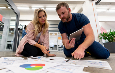 Man and woman look at graphs