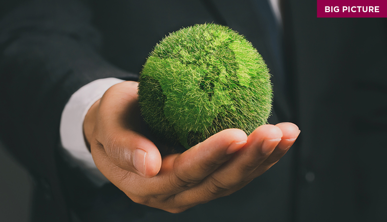 Hand holding a green representation of the world