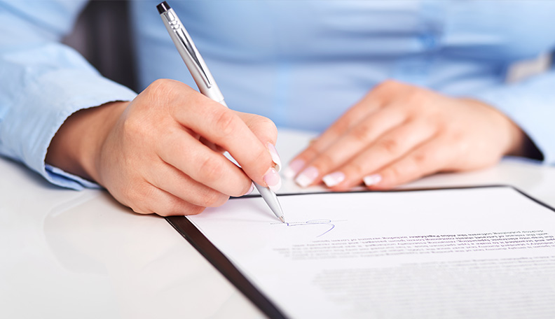 Image of a person signing a contract