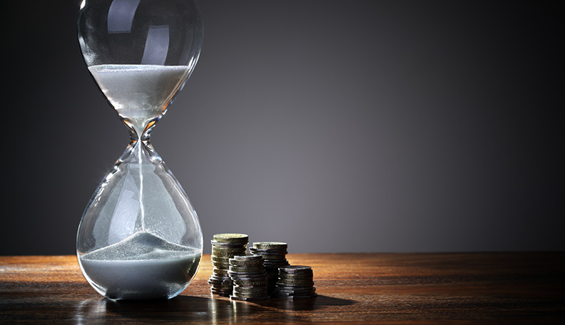 Image of an hourglass and piles of pound coins