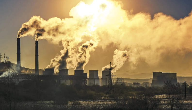 Image of factory chimneys releasing smoke into the atmosphere