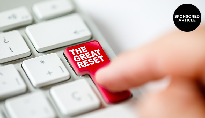 Image of a finger pressing the ‘enter’ key on a keyboard, which has been replaced with a red ‘THE GREAT RESET’ button