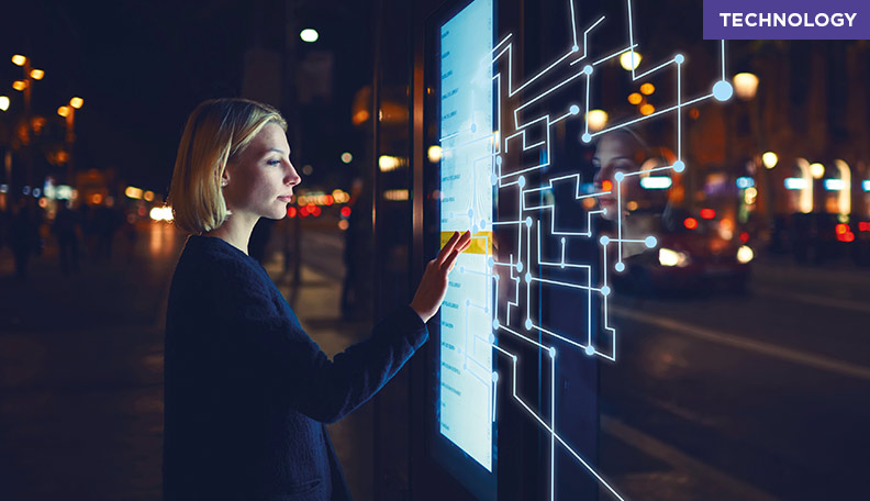 Image of a woman using a giant tablet on a city street