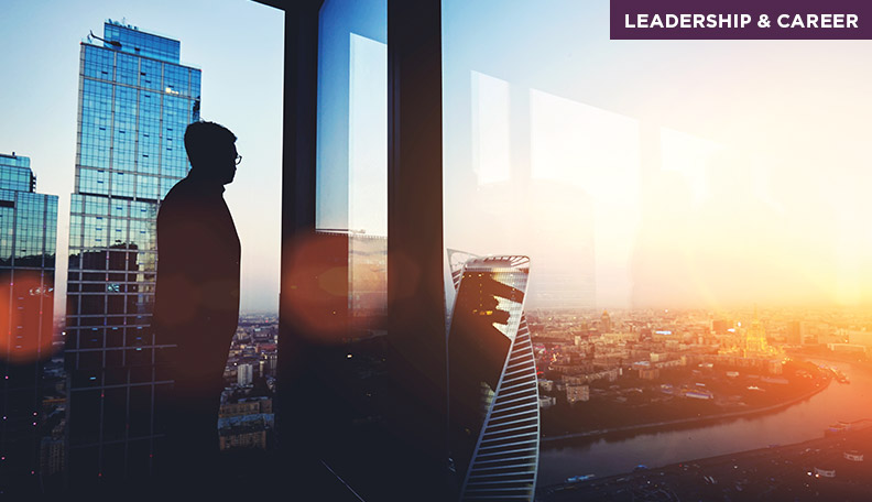 Image of a person in a corner office with a cityscape view