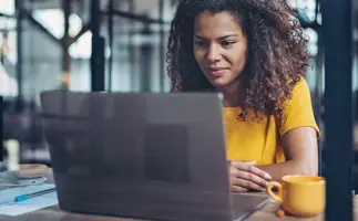 Woman smiling at her laptop, online learning