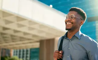 Professional man in finance and treasury smiling in front of office building