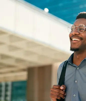 Professional man in finance and treasury smiling in front of office building
