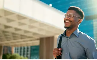 Professional man in finance and treasury smiling in front of office building
