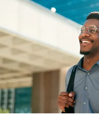 Professional man in finance and treasury smiling in front of office building