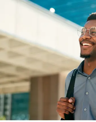 Professional man in finance and treasury smiling in front of office building